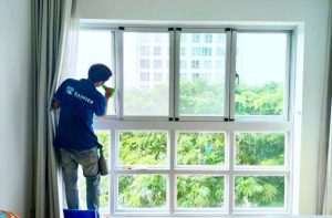 Kỹ thuật viên đang dán phim cách nhiệt chống tia UV lên cửa kính