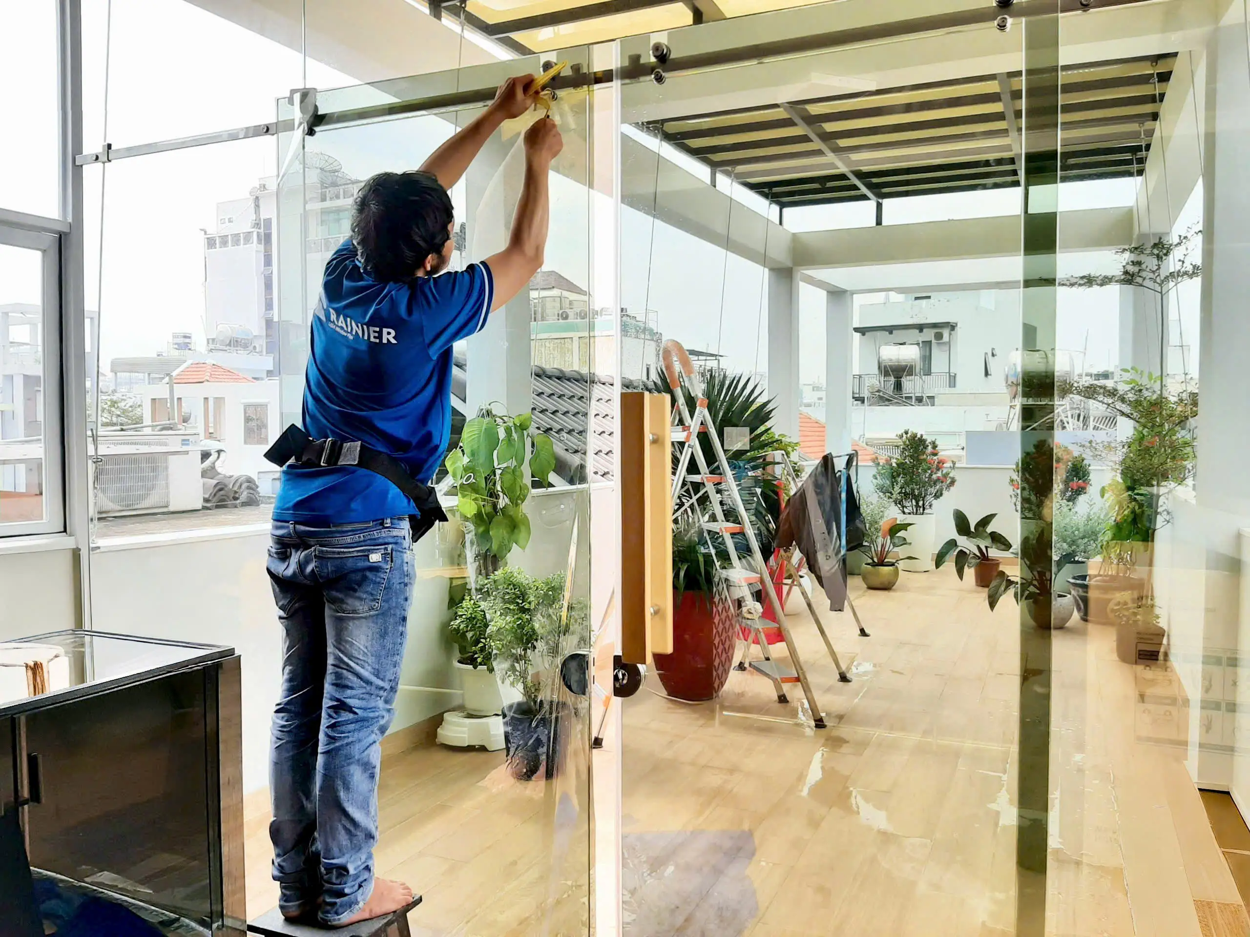Kỹ thuật viên thi công phim cách nhiệt Rainier tại cửa kính lớn nhà phố
