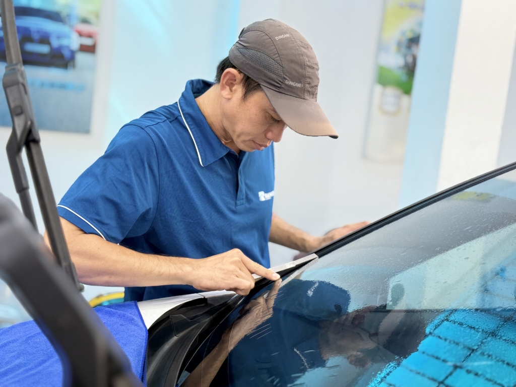 Kỹ thuật viên Rainier cắt và định hình phim cách nhiệt ô tô