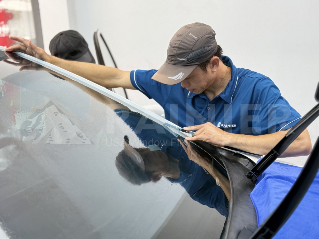 Kỹ thuật viên đang cẩn thận sấy phom kính lái chống chói trong phòng thi công kín tại Sơn La