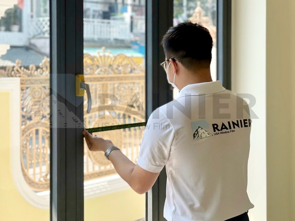 Kỹ thuật viên Rainier đo kính trước khi dán tại nhà cho khách tại Ninh Thuận